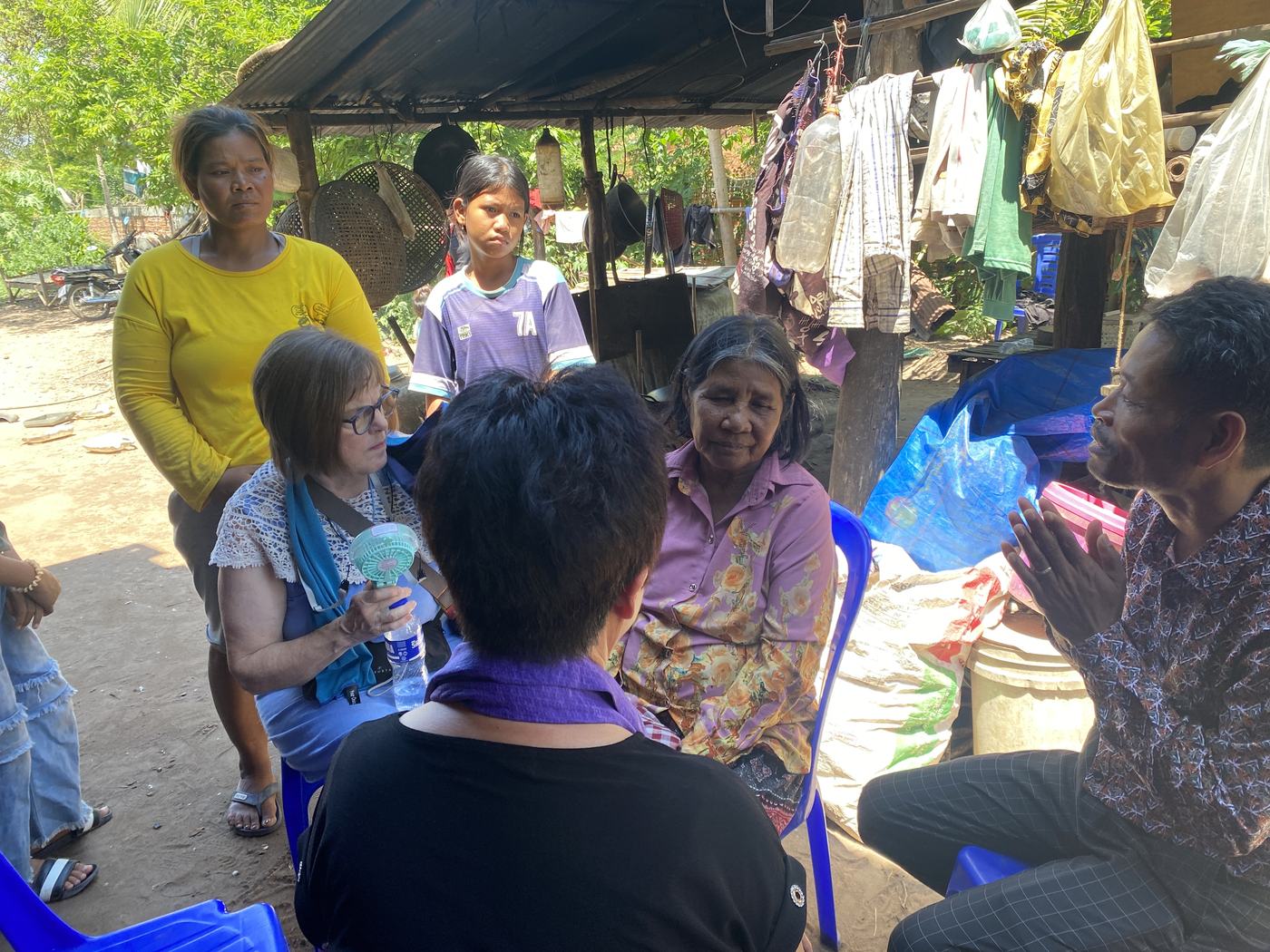 Prophet Soonhe Young and a team member sitting with a Cambodian family